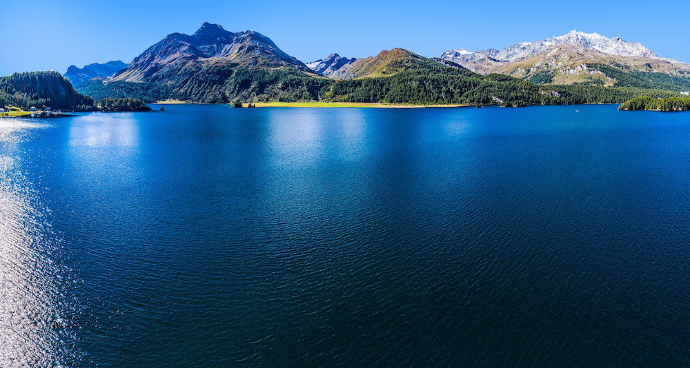 Eine Luftaufnahme eines Sees mit Bergen im Hintergrund.